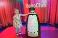 A girl at the interactive robot exhibition Robostars plays with a robot.