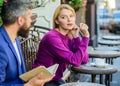 Girl interested what he reading. Guide to dating. Meeting people with similar interests. Man and woman sit cafe terrace Royalty Free Stock Photo