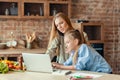 Girl interrupting her working mom, using laptop Royalty Free Stock Photo