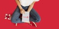 Girl with ipad in her hands, gifts, discounts, sitting on an isolated red background,Valentine`s Day