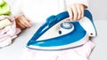 girl ironing baby clothes at home. My daughter helps my mother iron children\'s clothes. childhood concept. No Royalty Free Stock Photo