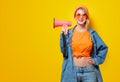 Girl in jeans clothes with pink megaphone