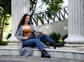 Brunette in jeans and glasses on marble surface Royalty Free Stock Photo