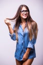 Girl in jeans shirt with glasses posing with different gesture in studio Royalty Free Stock Photo