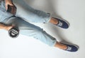 girl in jeans and sneakers sits on a white background Royalty Free Stock Photo