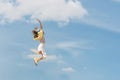 Girl during jump in the sky. Woman jumping through the air in front of beautiful cloudy sky. Carefree woman Royalty Free Stock Photo