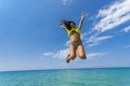 Girl jumping above water horizon