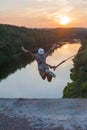 Girl jumping from the bridge. A girl with an incredible time is engaged in freestyle in bungee jumping. A young girl performs a