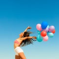Girl jumping with colorful balloons on sky background Royalty Free Stock Photo