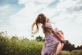 girl jumping in the field in a pink dress