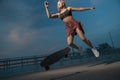 Girl jumping off a skateboard with headphones Royalty Free Stock Photo