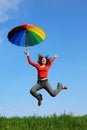 Girl jumping over green grass with umbrella Royalty Free Stock Photo