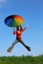 Girl jumping over green grass with umbrella Royalty Free Stock Photo