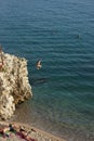 Girl Jumping from the Rock to the Sea