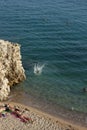 Girl Jumping from the Rock to the Sea