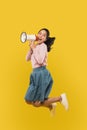 A girl jumping and screaming using a megaphone on