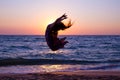 Girl jumping on the sea coast at sunrise Royalty Free Stock Photo