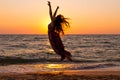 Girl jumping on the sea coast at sunrise Royalty Free Stock Photo