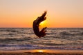 Girl jumping on the sea coast at sunrise Royalty Free Stock Photo