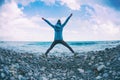 Girl jumping on the sea coast at sunset