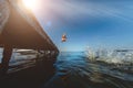 Girl jumping with a wooden bridge in the water in the summer.Toning Royalty Free Stock Photo