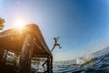 Girl jumping with a wooden bridge in the water in the summer.Toning Royalty Free Stock Photo