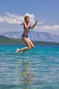 Girl jumping from a wooden pier in the sea Royalty Free Stock Photo