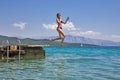 Girl jumping from a wooden pier in the sea Royalty Free Stock Photo