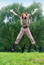 The girl jumps on a grass and trees as a backgroun Royalty Free Stock Photo