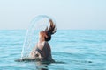 Girl jumps out of the water creating a spray over her head Royalty Free Stock Photo