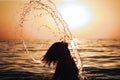 Girl jumps out of the water creating a spray over her head Royalty Free Stock Photo