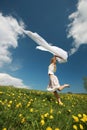 Girl jumps over dandelion field Royalty Free Stock Photo