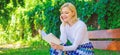 Girl keen on book keep reading. Reading literature as hobby. Girl sit bench relaxing with book, green nature background