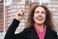 Girl with key looks upwards against many-storeyed Royalty Free Stock Photo