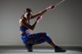 Girl kickboxer pulling a chain with pink hand wraps