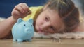 girl kid child puts coins save in a piggy bank pig. economy finance crisis coronavirus fund concept. little girl save