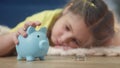 girl kid child puts coins save in a piggy bank pig. economy finance crisis coronavirus fund concept. little girl save