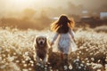 Girl kid with dog running on nature in a field of flowers on a summer day at sunset Royalty Free Stock Photo