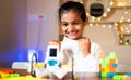 Girl Kid got excited after successful completion of DIY robot at home - concept of childhood development, scientific experiment