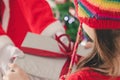 Girl kid holding gift box and red ribbon bow of presents by Santa Claus on Christmas day. Merry Christmas and happy holidays. Girl Royalty Free Stock Photo