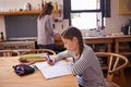 Girl, kid and homework with studying in kitchen with writing, development or notes for education in house. Child Royalty Free Stock Photo