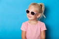 Girl kid in sunglasses isolated on blue background. Fashion cute pretty child Royalty Free Stock Photo