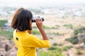 Girl kid watching far destinations by using binocular at hill top during summer camp - concept of exploration Royalty Free Stock Photo