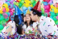 Girl kissed by her parents at birthday party Royalty Free Stock Photo