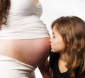Girl kissing her moms pregnant tummy