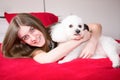 Girl kissing hugging her good friend dog in bed Royalty Free Stock Photo