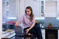 Girl in kitchen with laptop