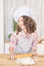 Girl in kitchen. Process of cooking buns. Little cook. White cap