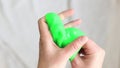 The girl kneads green slime. Toy store concept