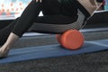 Girl kneads the thigh muscles with an MFR roller. Myofascial release. Self-massage. Fascia release